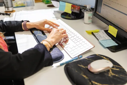 Three women on the Jos Family Law team collaborating with laptops and branded folders
